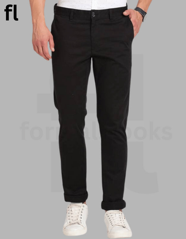 A person standing against a white background, wearing black cotton pants and white sneakers.